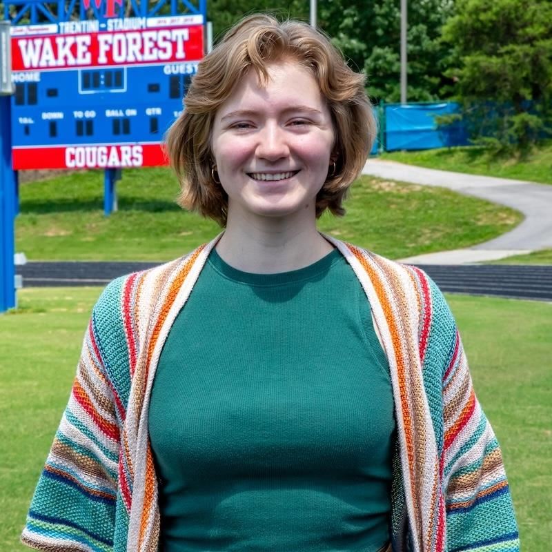 Jillian smiles in front of the stadium scoreboard